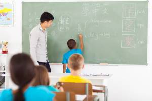 Canstock kid writing in classroom